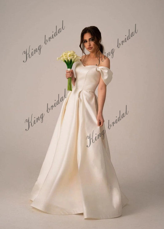 Vestidos de novia de satén marfil con corsé y cordones. Sencillo y modesto vestido de novia blanco con hombros descubiertos y abertura alta. Moderno vestido de novia de corte A.