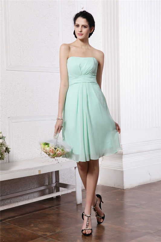Vestido de dama de honor corto de gasa con pliegues, sin mangas, con corte tubo/columna y sin tirantes, ideal para invitadas de boda.