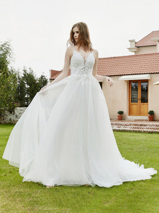 Vestido de novia color marfil con escote en V pronunciado y corpiño de encaje y tirantes finos.