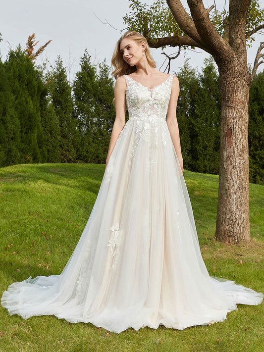 Vestido de novia con escote en V, apliques y cola capilla en color marfil/champán