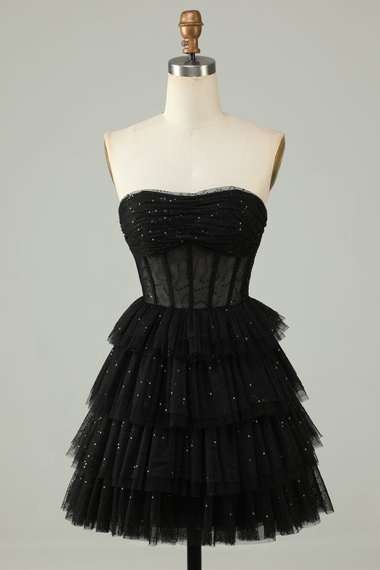Vestido de fiesta con corsé negro, brillante, con volantes y capas.