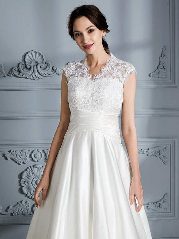 Vestidos de novia de satén con escote en V, sin mangas y cola de corte.