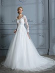 Vestido de novia de tul con escote en V y mangas largas y cola de corte.