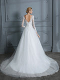 Vestido de novia de tul con escote en V y mangas largas y cola de corte.