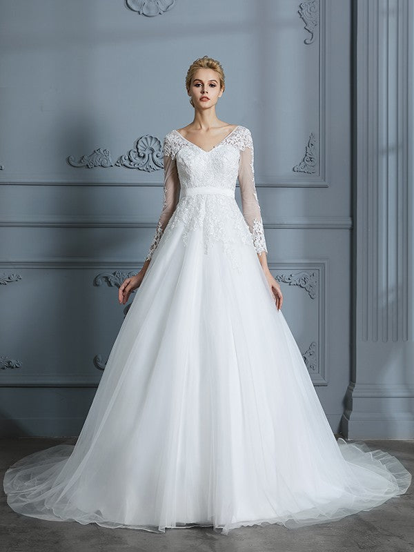 Vestido de novia de tul con escote en V y mangas largas y cola de corte.