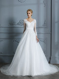 Vestido de novia de tul con escote en V y mangas largas y cola de corte.