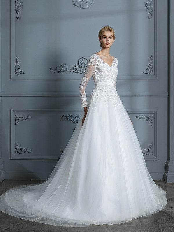 Vestido de novia de tul con escote en V y mangas largas y cola de corte.