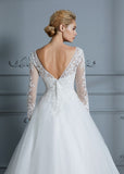 Vestido de novia de tul con escote en V y mangas largas y cola de corte.