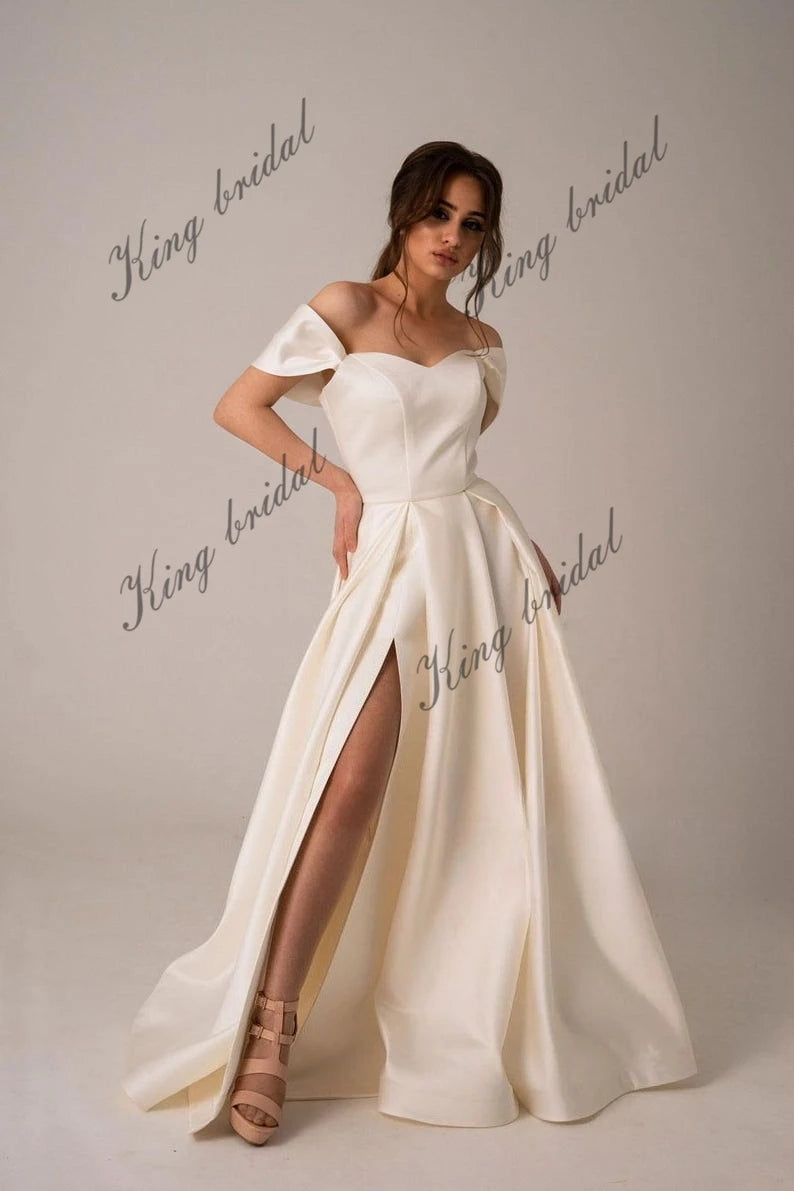 Vestidos de novia de satén marfil con corsé y cordones. Sencillo y modesto vestido de novia blanco con hombros descubiertos y abertura alta. Moderno vestido de novia de corte A. 