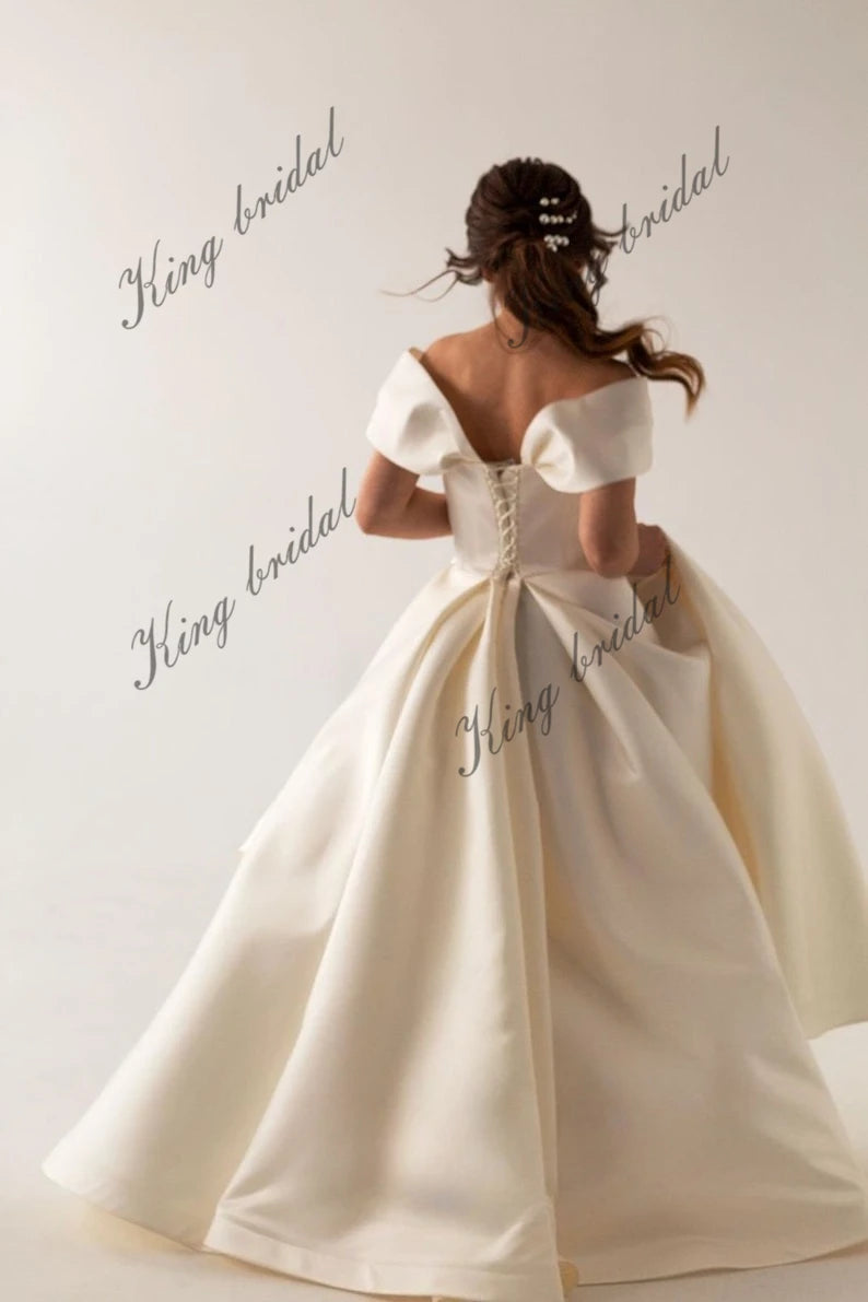 Vestidos de novia de satén marfil con corsé y cordones. Sencillo y modesto vestido de novia blanco con hombros descubiertos y abertura alta. Moderno vestido de novia de corte A. 