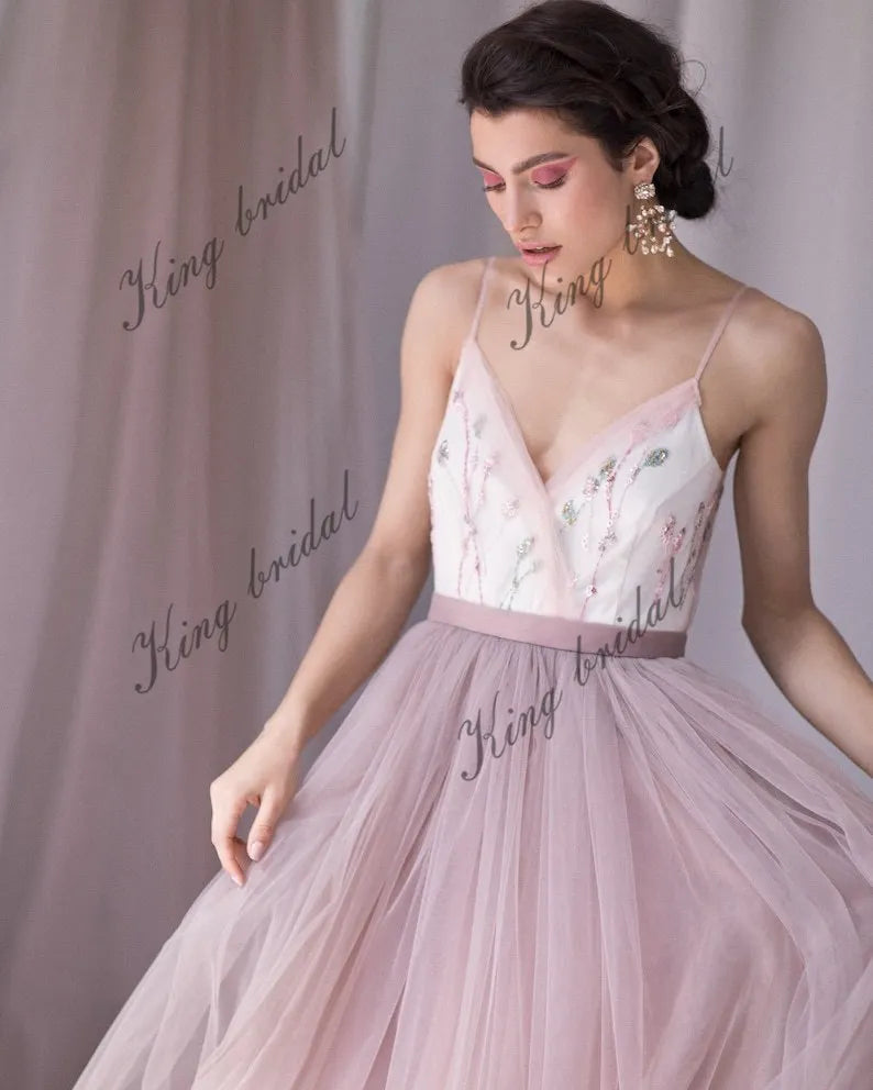 Vestido de novia con escote en V, espalda halter con cuentas y capas de tul. Vestido de novia no tradicional. Vestido de novia en color rubor pálido con flores de colores. 