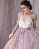 Vestido de novia con escote en V, espalda halter con cuentas y capas de tul. Vestido de novia no tradicional. Vestido de novia en color rubor pálido con flores de colores. 