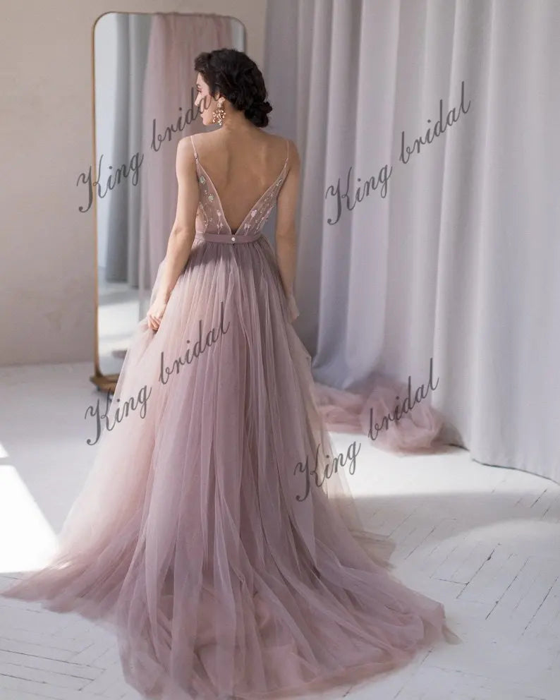 Vestido de novia con escote en V, espalda halter con cuentas y capas de tul. Vestido de novia no tradicional. Vestido de novia en color rubor pálido con flores de colores. 