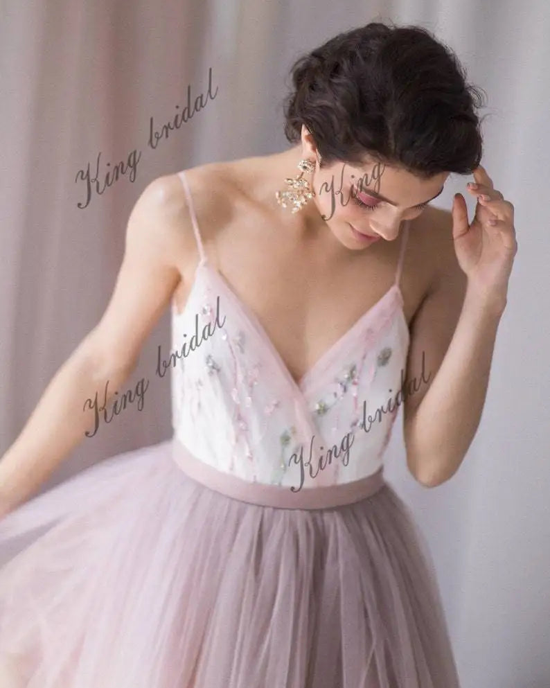 Vestido de novia con escote en V, espalda halter con cuentas y capas de tul. Vestido de novia no tradicional. Vestido de novia en color rubor pálido con flores de colores. 