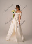 Vestidos de novia de satén marfil con corsé y cordones. Sencillo y modesto vestido de novia blanco con hombros descubiertos y abertura alta. Moderno vestido de novia de corte A. 