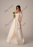 Vestidos de novia de satén marfil con corsé y cordones. Sencillo y modesto vestido de novia blanco con hombros descubiertos y abertura alta. Moderno vestido de novia de corte A. 