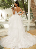 Vestido de novia de tul con apliques y escote en V, sin mangas y cola capilla.