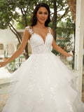 Vestido de novia de tul con apliques y escote en V, sin mangas y cola capilla.