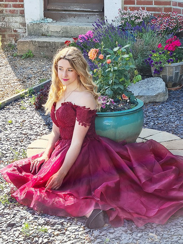Vestido de noche de fiesta de organza con hombros descubiertos, sin mangas y apliques asimétricos.
