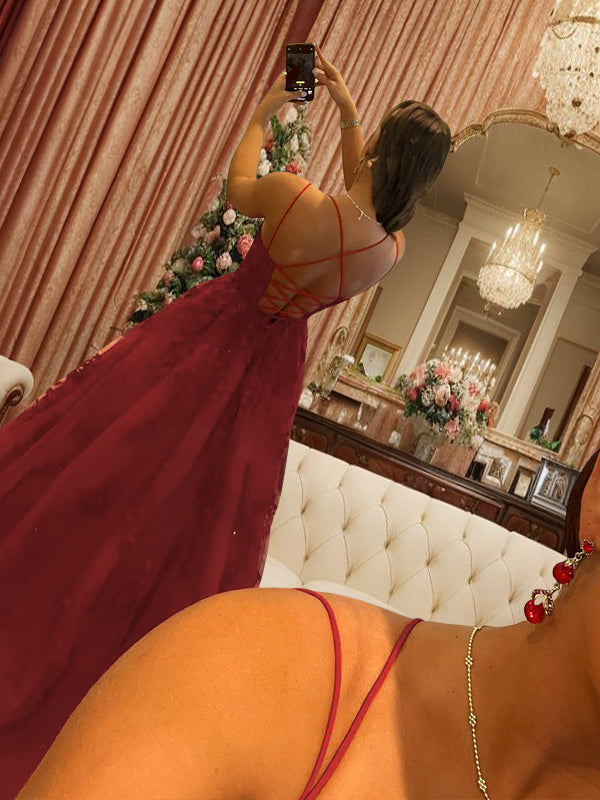 Vestido de fiesta de tul con apliques y tirantes finos, sin mangas, con cola larga y escote barrido.