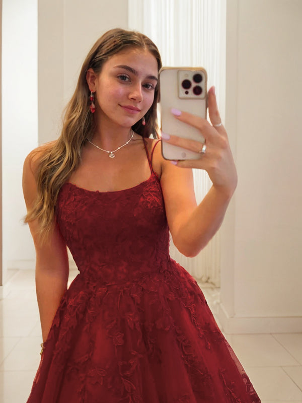 Vestido de fiesta de tul con apliques y tirantes finos, sin mangas, con cola larga y escote barrido.