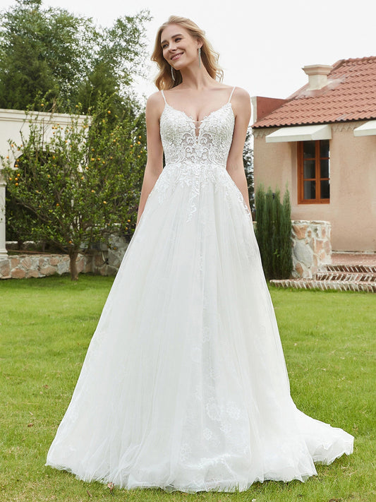 Vestido de novia color marfil con tirantes finos, escote en V pronunciado y espalda descubierta.