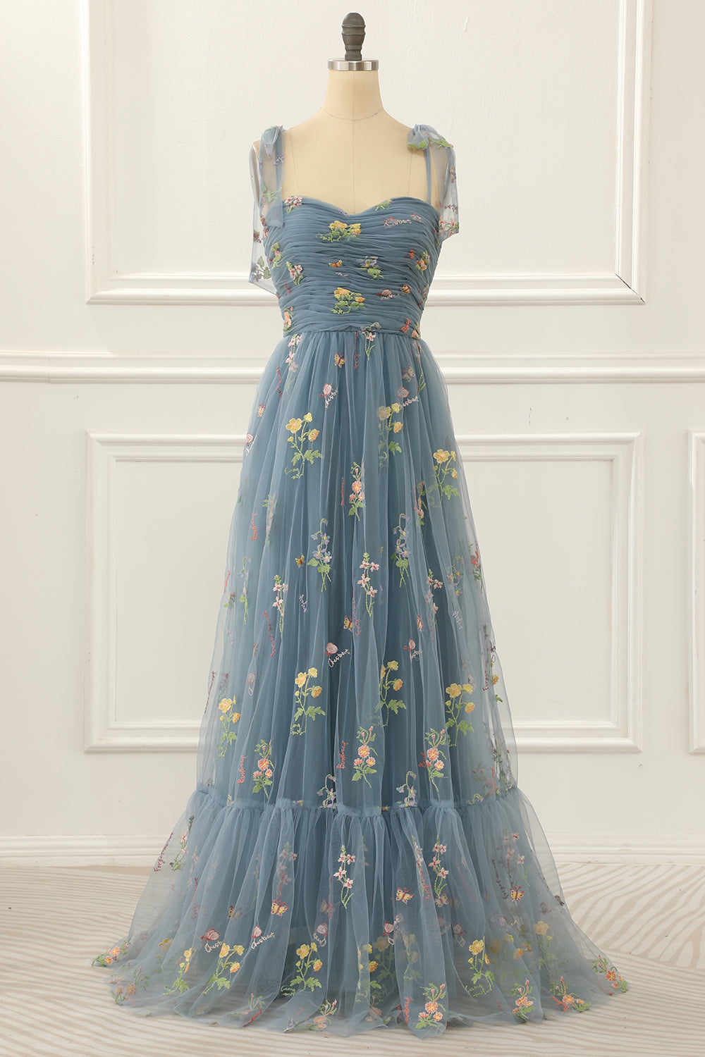 Vestido de fiesta de tul azul grisáceo con corte en A y bordados.
