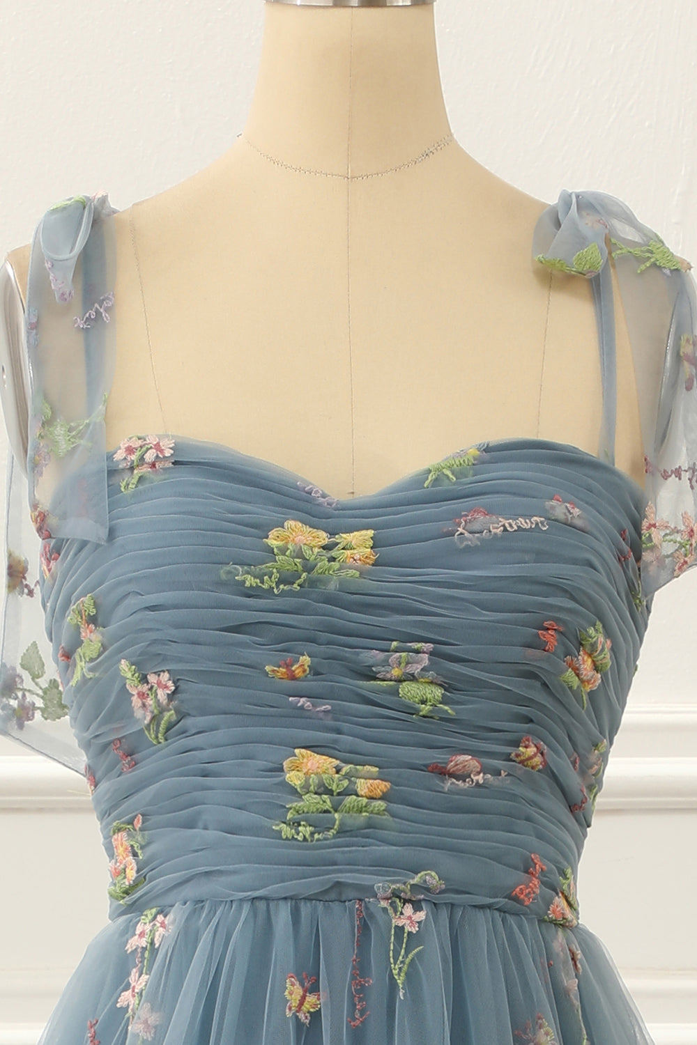 Vestido de fiesta de tul azul grisáceo con corte en A y bordados.
