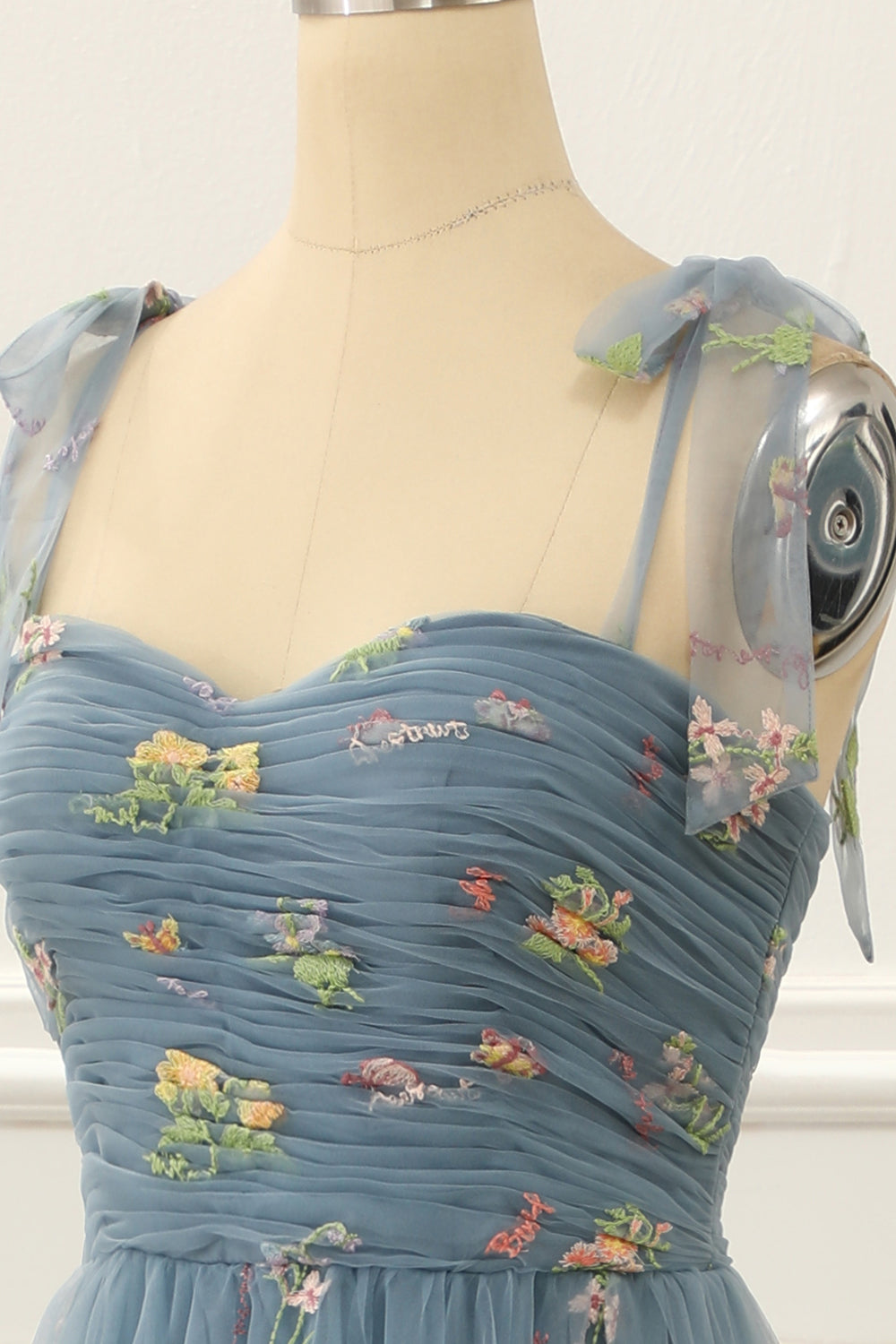 Vestido de fiesta de tul azul grisáceo con corte en A y bordados.